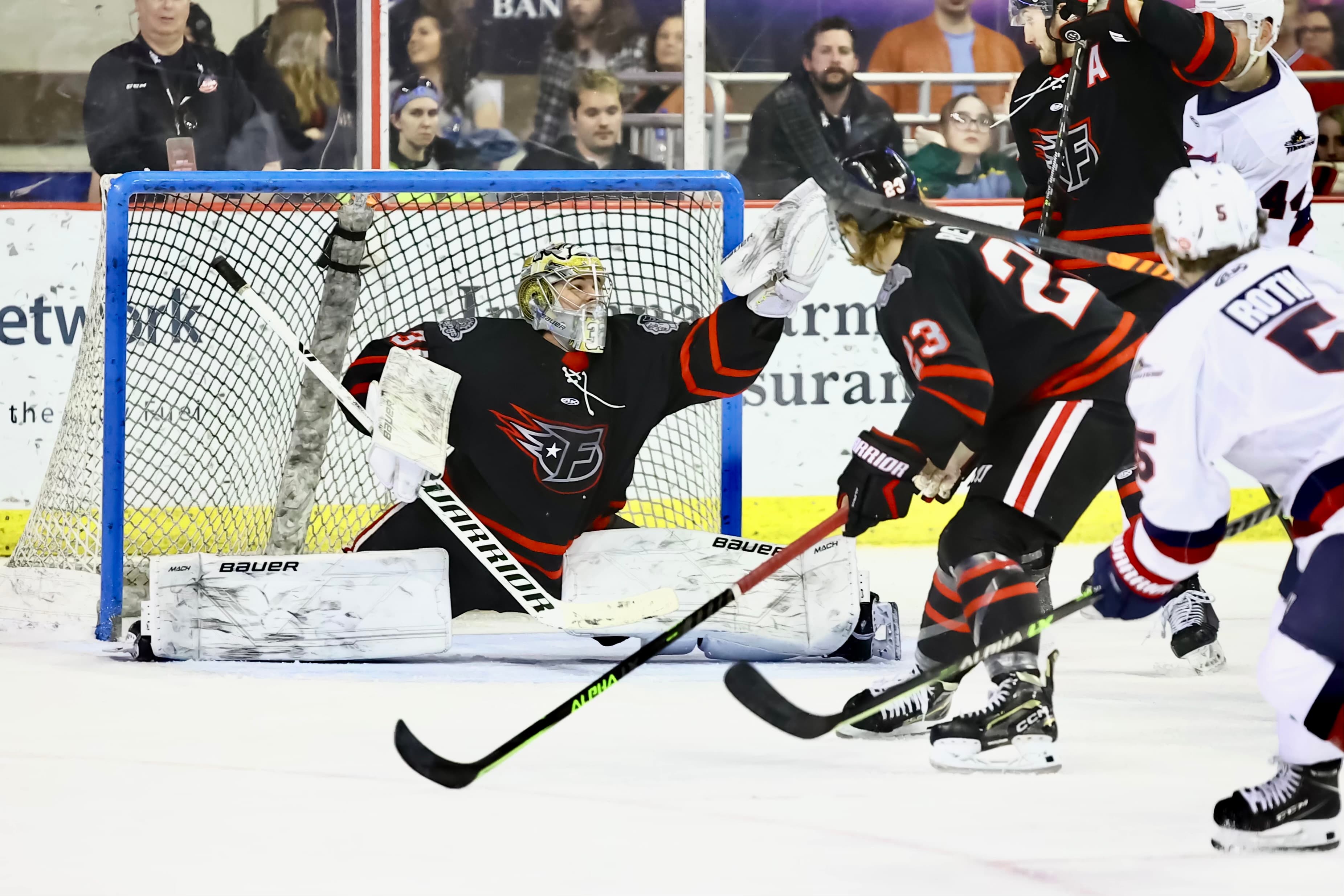 Cam Gray making a glove save in an Indy Fuel game against a Stingrays forward.