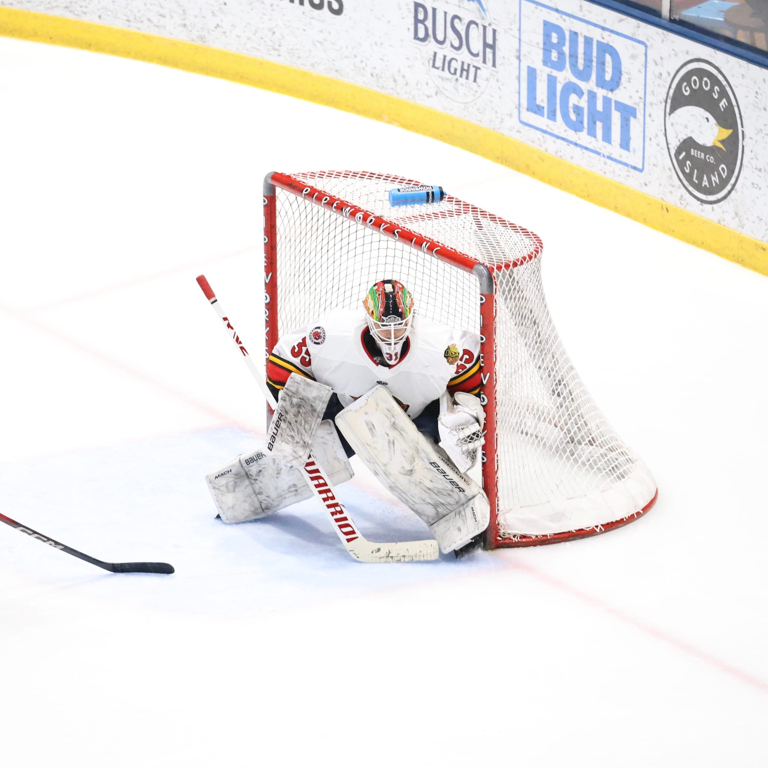 Cam Gray tracking the puck in a white Indy Fuel jersey.
