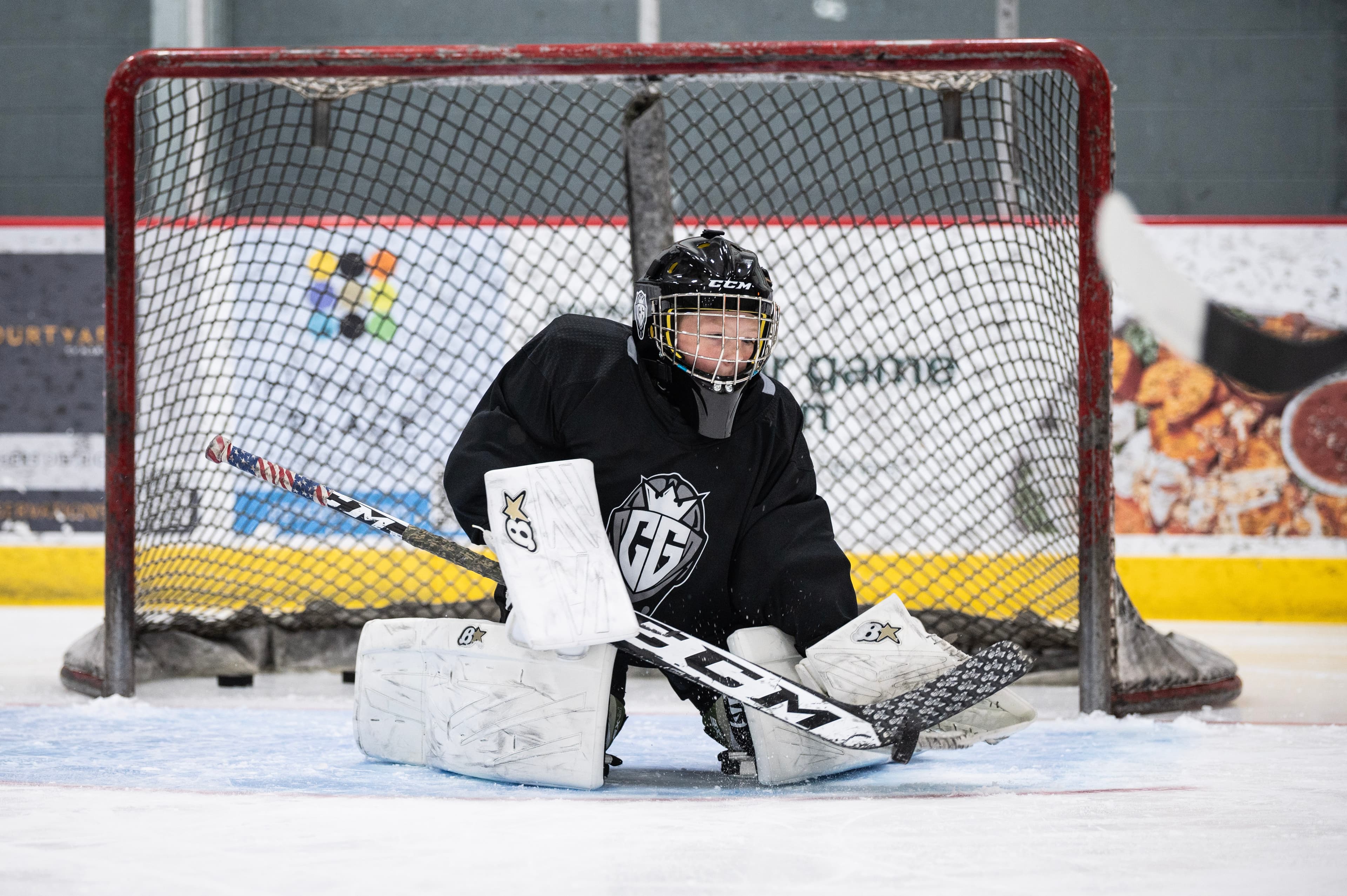 A CGG goalie down in the butterfly, sealing the post.