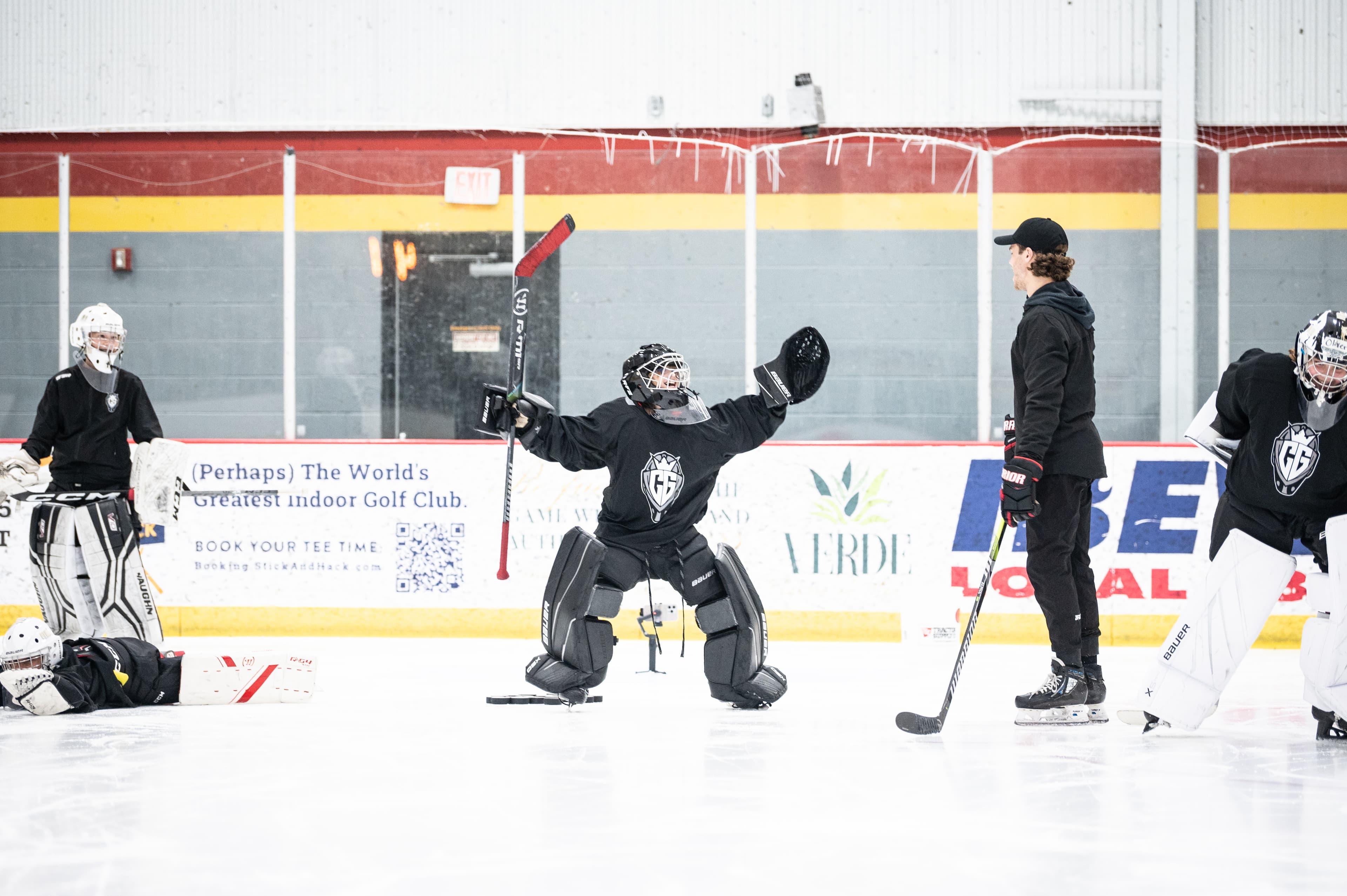 Cam leading a summer session on the ice, goalies around him.