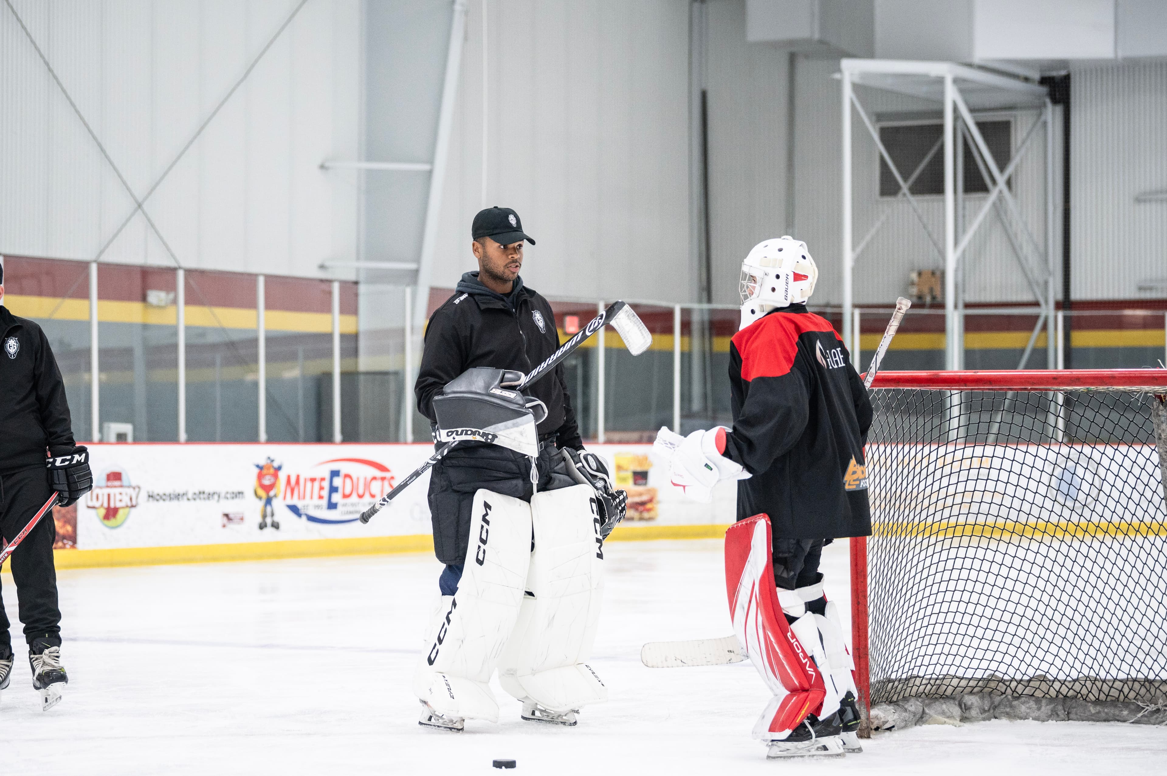 A CGG coach working with a goalie at the net.